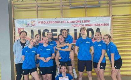 drużyna sportowa w niebieskich strojach z nauczycielem