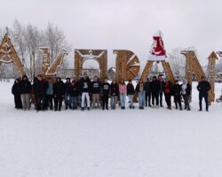 grupa uczniów stojących przez napisem Zakopane , śnieg