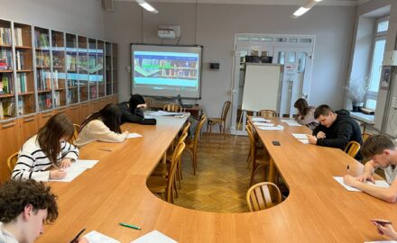 uczniowie siedzący prze stole konferencyjnym
