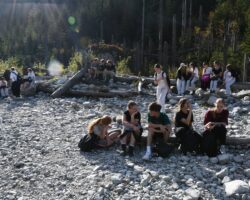 Uczniowie siedzą na ławkach zrobionych z drzewa