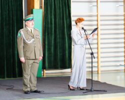 dyrektor przemawiający i nauczyciel w mundurze